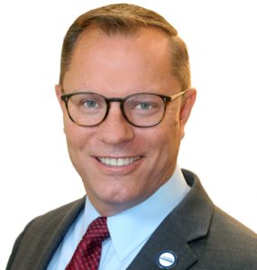 a man wearing glasses and a suit